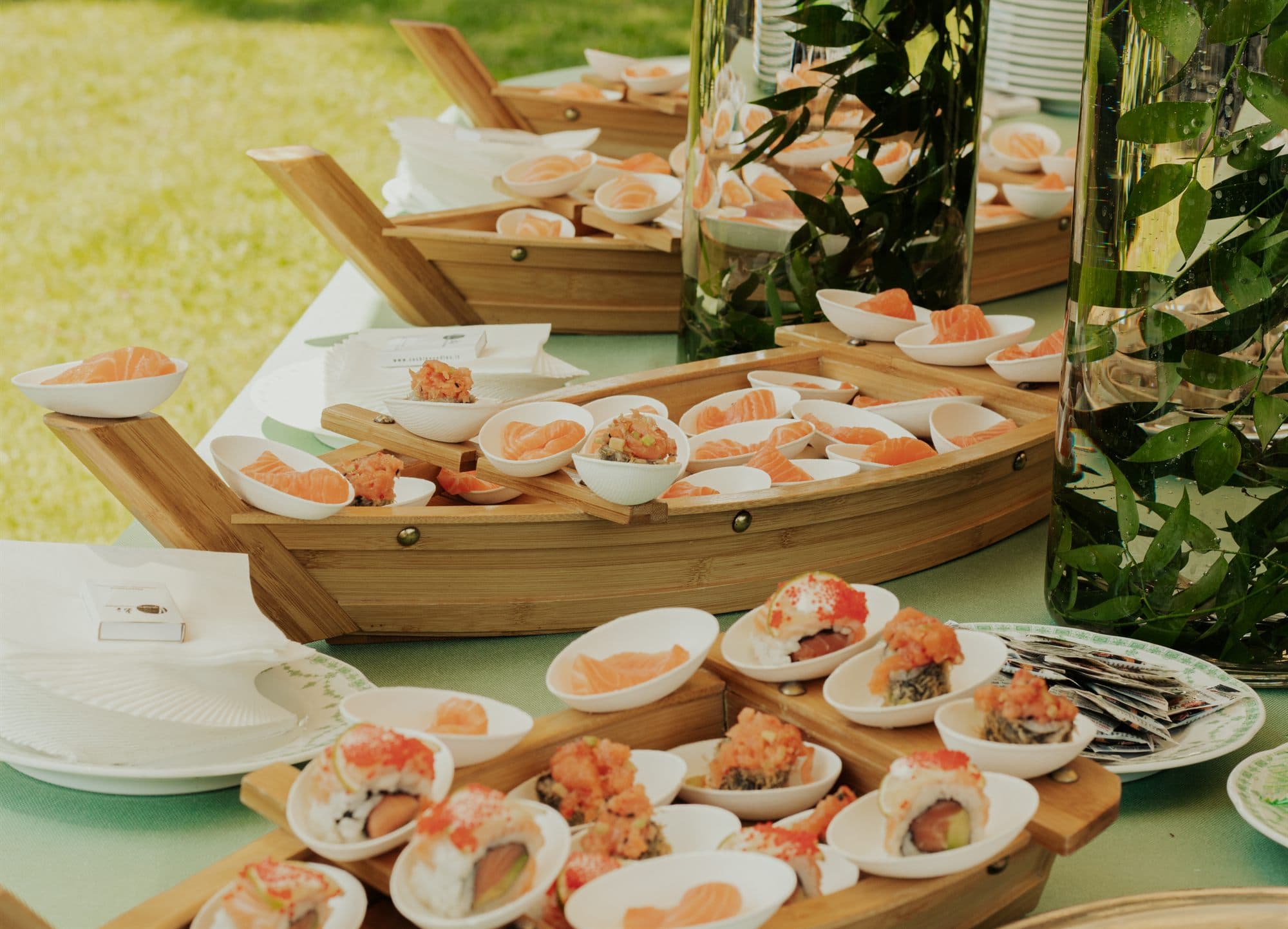 Buffet di sushi allestito all’aperto su barche di bamboo