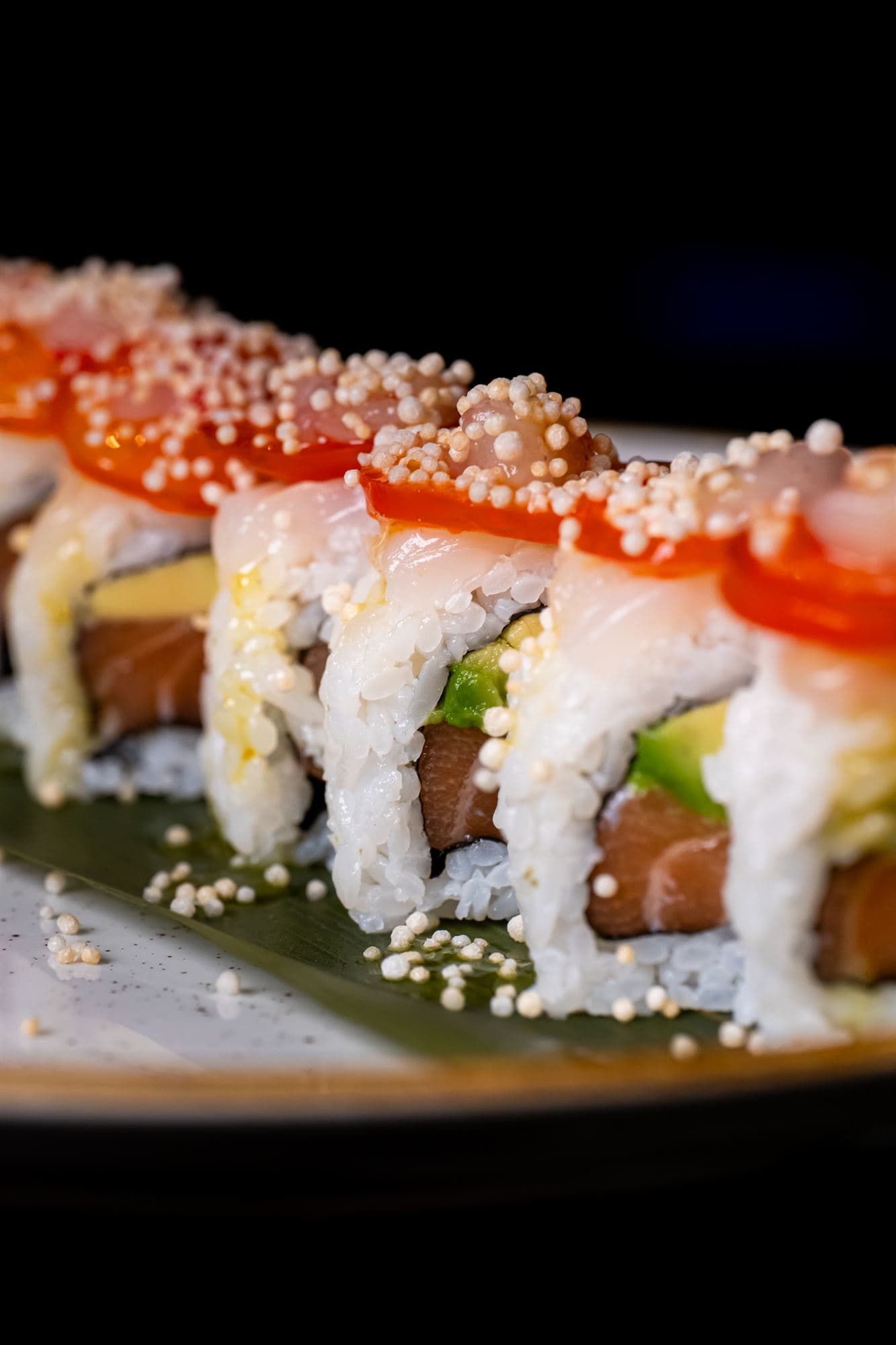 Uramaki con salmone e perline di riso soffiato in primo piano