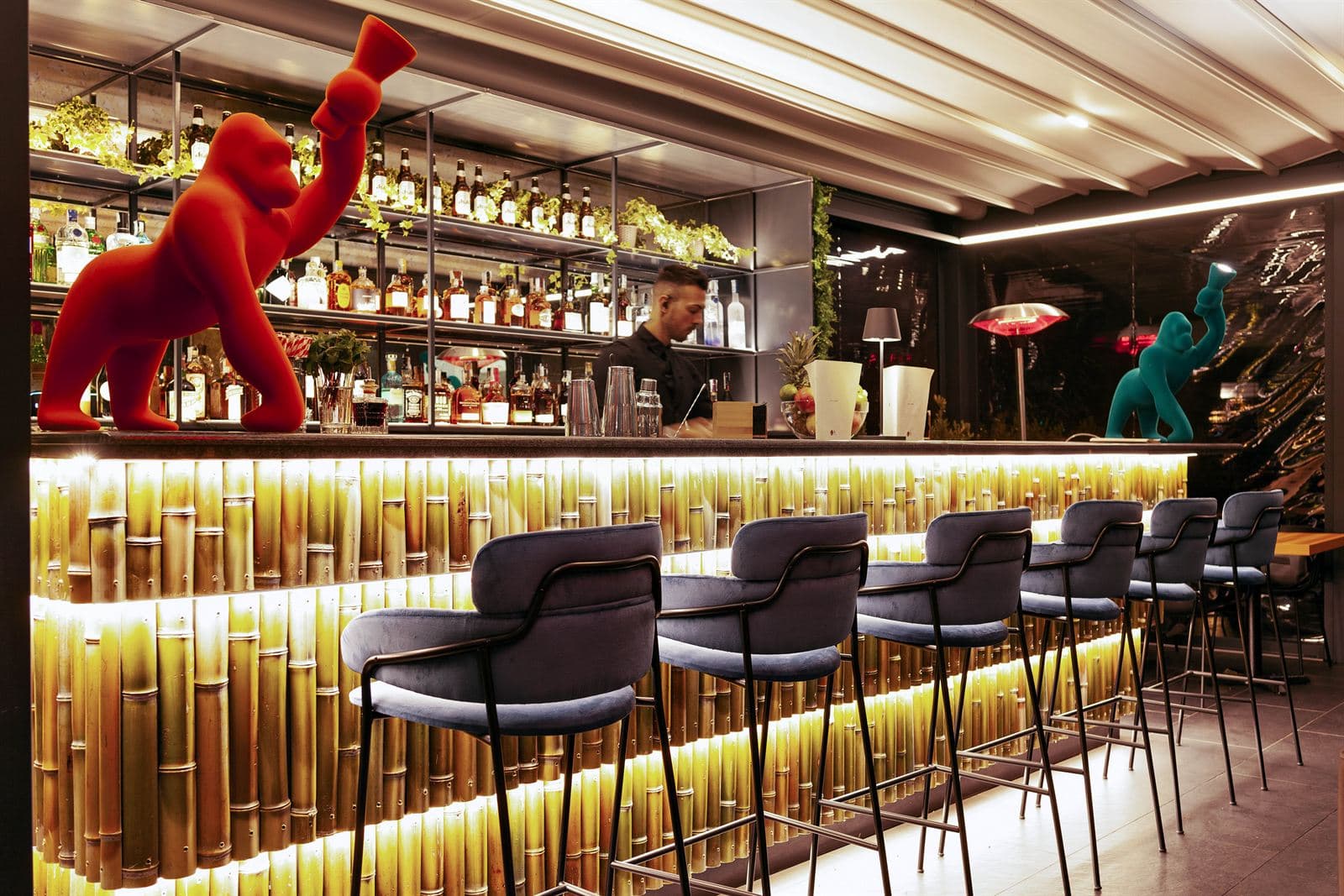 Il bancone bar con le bottiglie e gli sgabelli